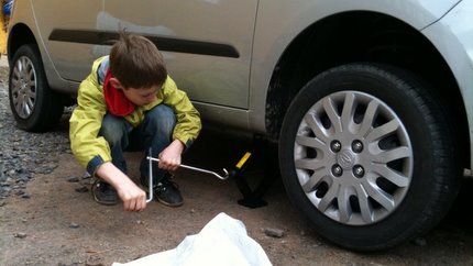 Hier ist der letzte Reifen montiert und das Auto wird bereits wieder herunter gelassen 
